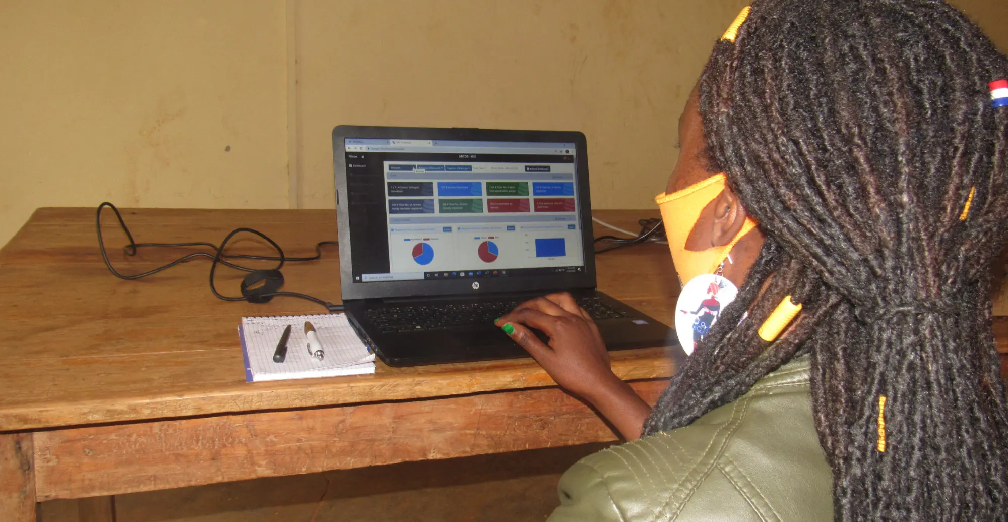 A project officer works with the web dashboard on a laptop